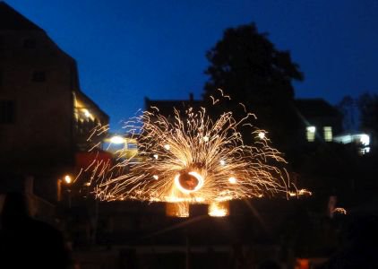 Sparkle Poi: ein Funkenregen sprüht in der Abenddämmerung über den Platz.