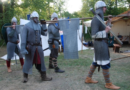 Vier gerüstete Claymore-Ritter in Kettenhemden mit Nasalhelmen, Äxten und Schilden im Lager.