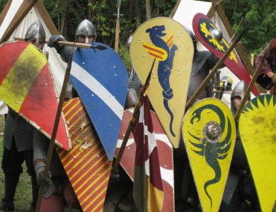Schildwall der Gruppe Claymore: dicht gestaffelte bemalte Normannenschilde und Speere.
